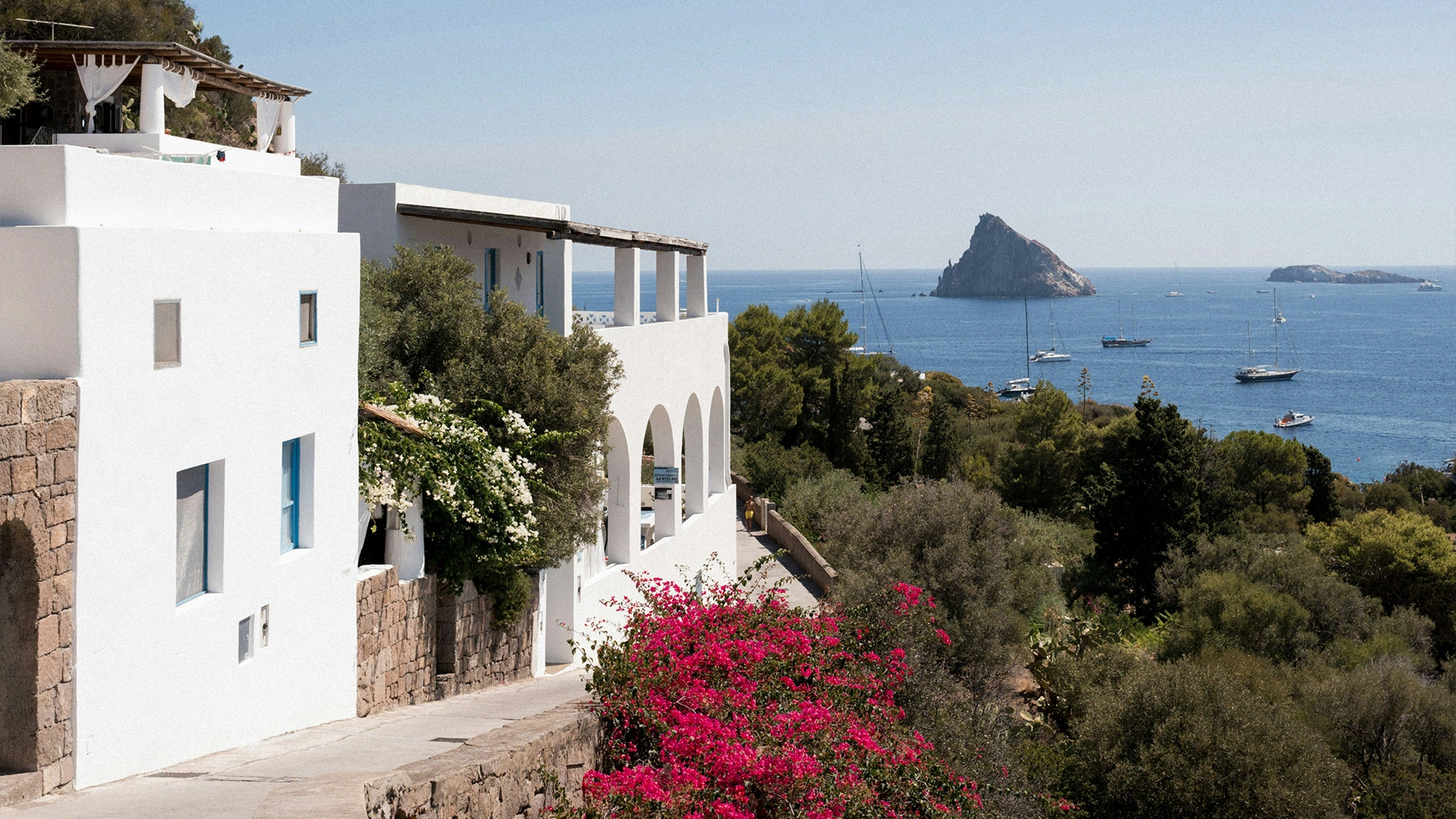 Whitewashed houses above the sea looking out towards Strombolicchio rock